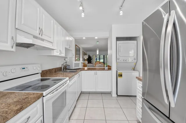 a kitchen with white cabinets and refrigerator