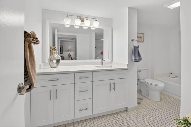 a bathroom with a sink a toilet and a mirror