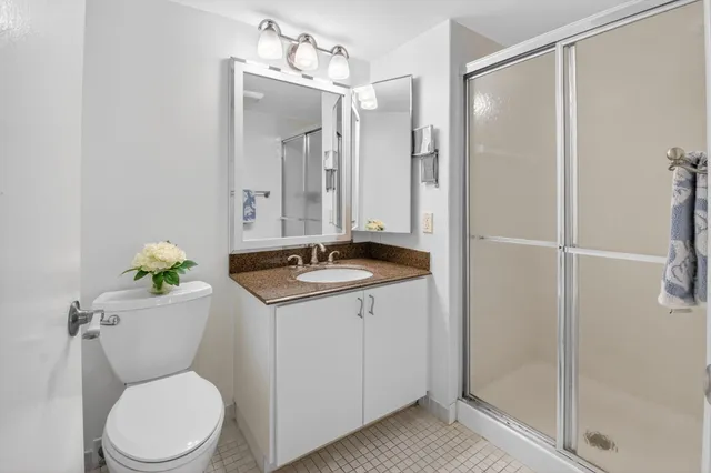 a bathroom with a granite countertop sink toilet and shower
