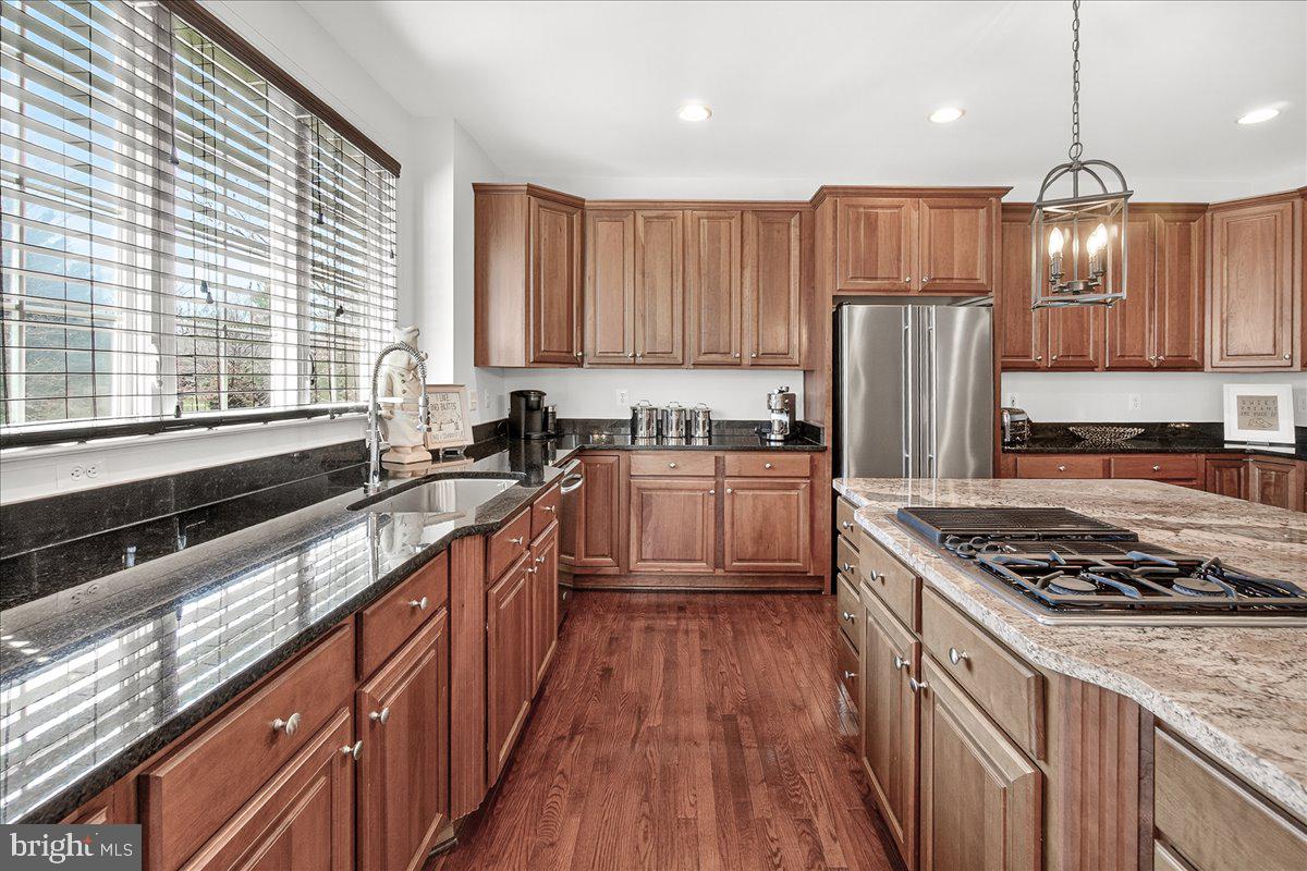 411 William Plummer Street New Market, MD 21774 - Photo 22 of 89 a kitchen with stainless steel appliances granite countertop a stove a sink dishwasher a refrigerator and a wooden cabinets