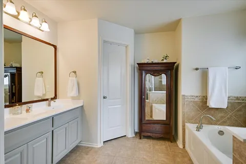 a bathroom with a tub sink and mirror