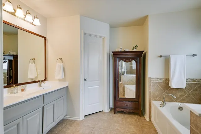 a bathroom with a tub sink and mirror