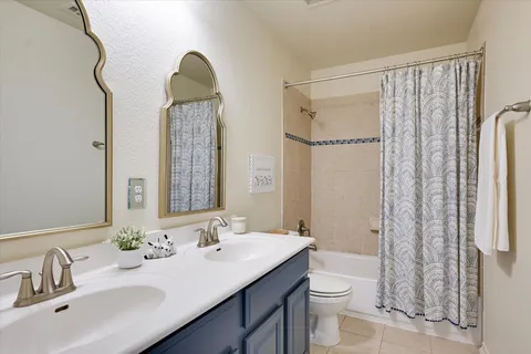 a bathroom with a double vanity sink toilet and shower