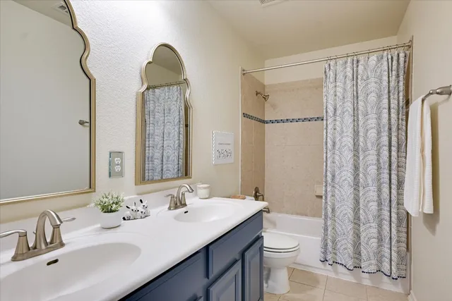 a bathroom with a double vanity sink toilet and shower