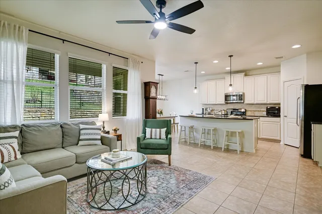 a living room with furniture and a large window with kitchen view