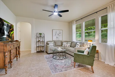a living room with furniture a flat screen tv and a large window