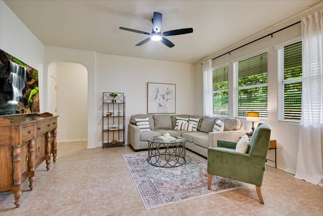 a living room with furniture a flat screen tv and a large window