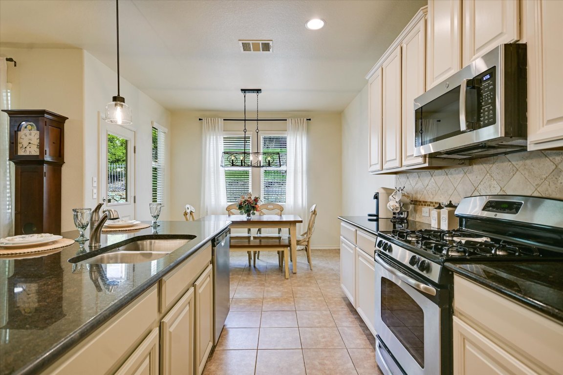 7212 Lookout Bluff Terrace, Unit D18 Austin, TX 78735 - Photo 6 of 22 a kitchen with stainless steel appliances a sink stove and microwave