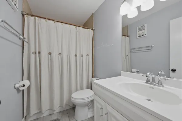 a bathroom with a sink a toilet and shower curtain