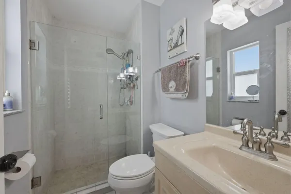 a bathroom with a sink a toilet a mirror and shower curtain