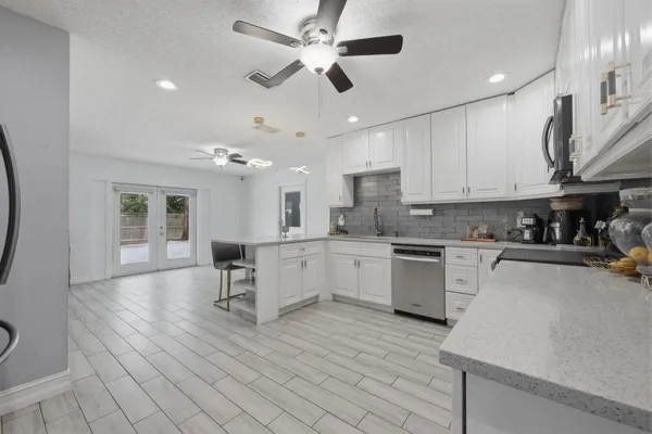 a kitchen with stainless steel appliances kitchen island hardwood floor sink stove and cabinets
