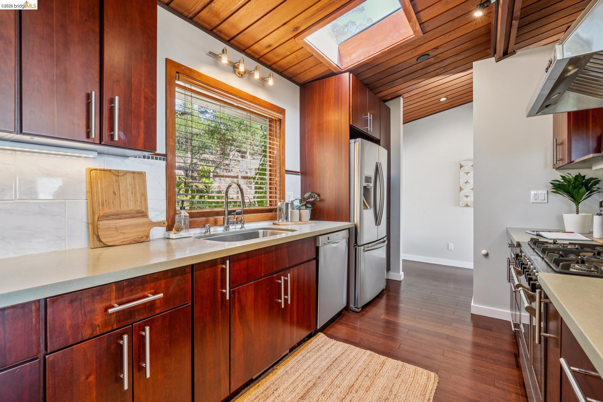 1394 Queens Road Berkeley, CA 94708 - Photo 11 of 63 Wood-finish ceiling and flooring with a skylight, ample wood-finish cabinetry, and a stainless steel appliance suite