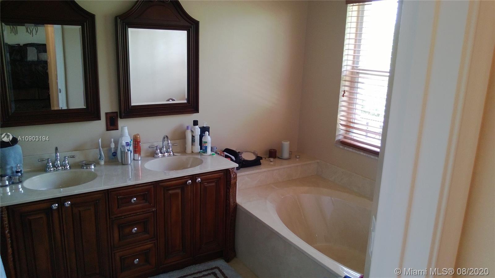 15751 Southwest 20th Street Miramar, FL 33027 - Photo 23 of 34 a bathroom with a granite countertop sink and a mirror