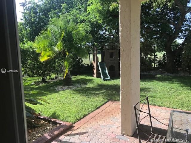 15751 Southwest 20th Street Miramar, FL 33027 - Photo 34 of 34 a view of backyard with a table and a chairs and a large tree