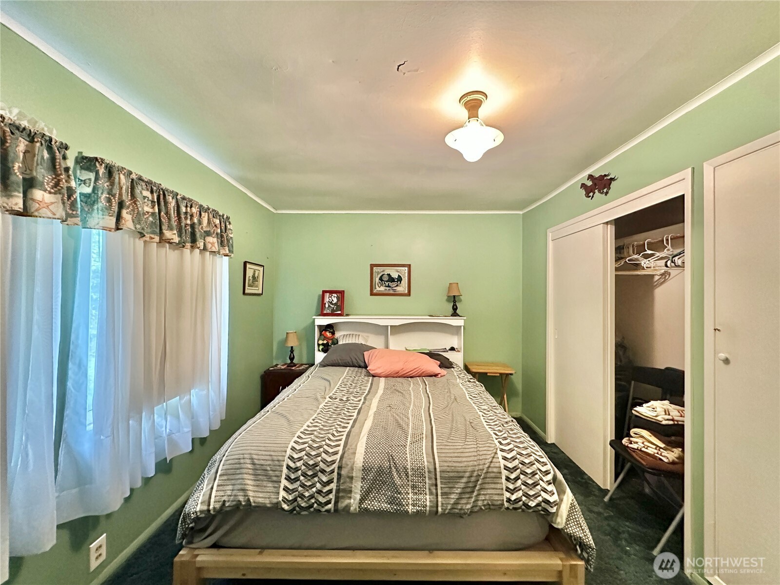 945 Highway 101 Cosmopolis, WA 98537 - Photo 16 of 39 a bedroom with a large bed and a chandelier