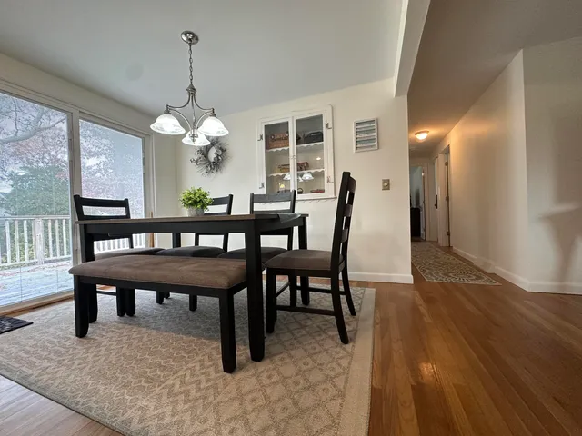 a view of a dining room with furniture a chandelier and wooden floor