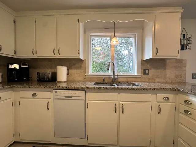 a kitchen with granite countertop white cabinets and white appliances