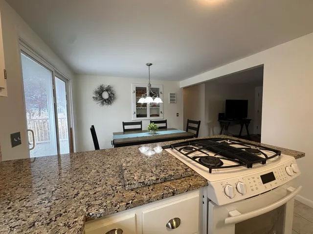 a kitchen with granite countertop a stove and a sink