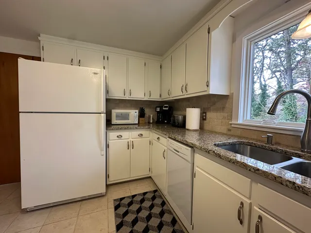 a kitchen with a refrigerator sink and cabinets