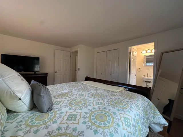 a bedroom with a bed and a flat screen tv