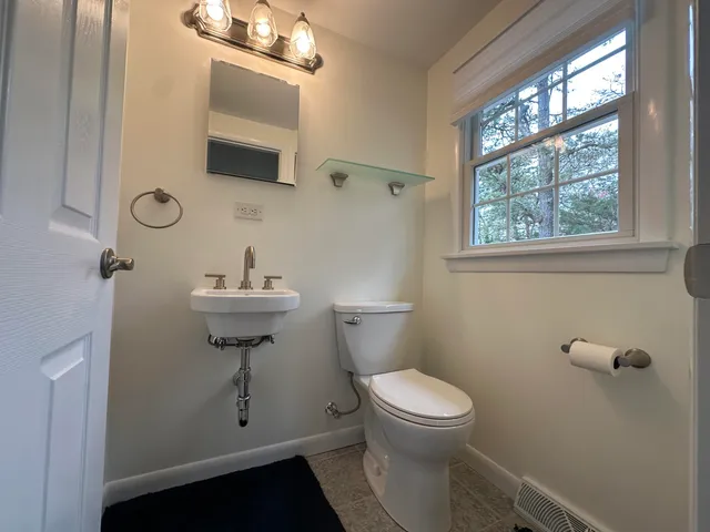 a bathroom with a sink a mirror a toilet and shower