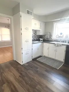 a kitchen with granite countertop white cabinets and white appliances