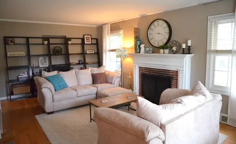 a living room with furniture a fireplace and a large window