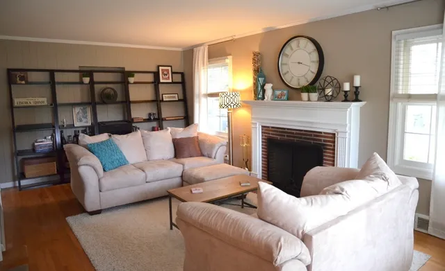 a living room with furniture a fireplace and a large window