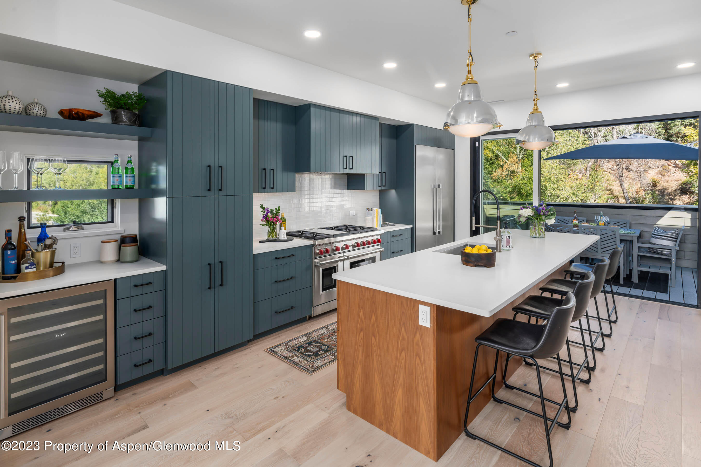 22840 Two Rivers Road, Unit 300 Basalt, CO 81621 - Photo 7 of 28 a kitchen with stainless steel appliances kitchen island granite countertop a table chairs in it and wooden floors