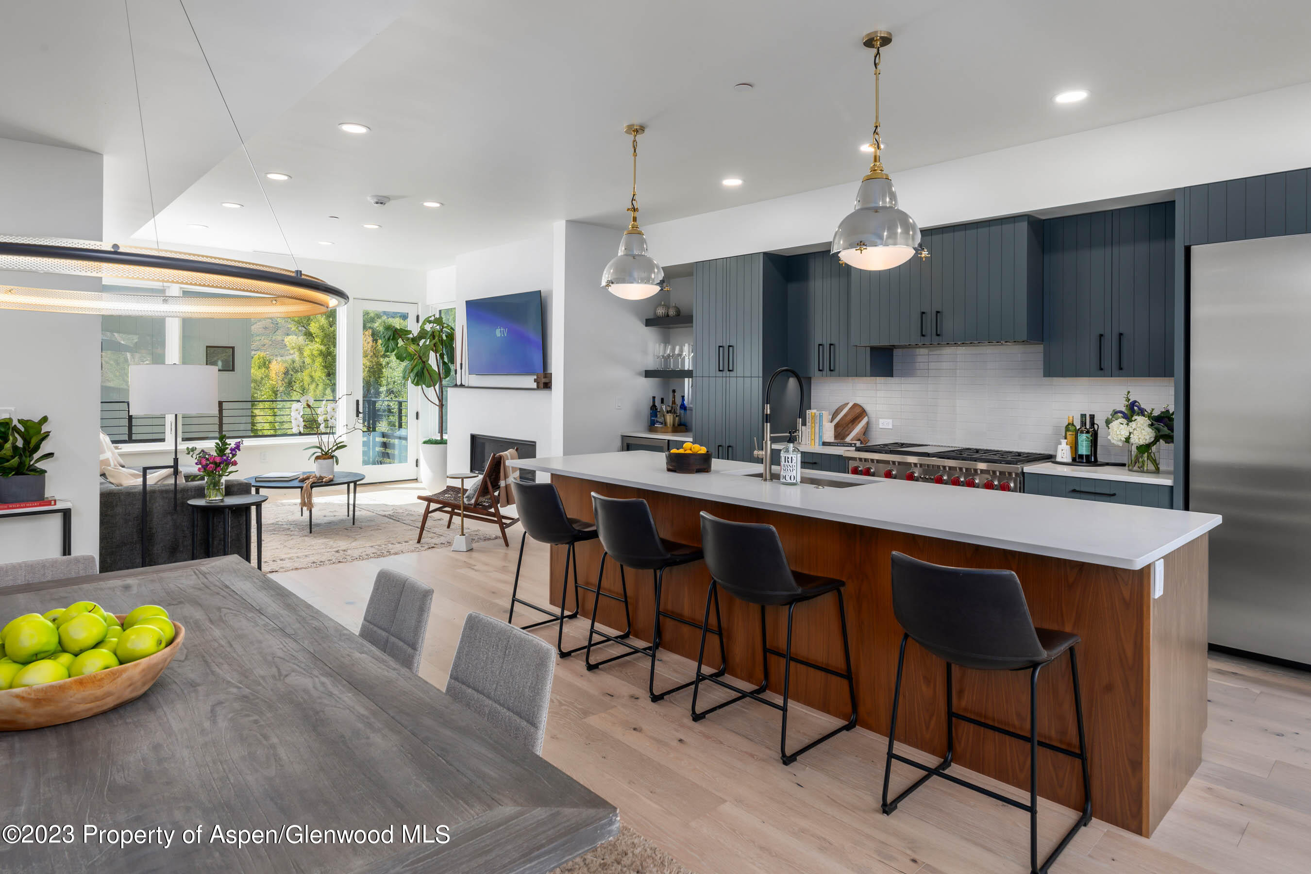 22840 Two Rivers Road, Unit 300 Basalt, CO 81621 - Photo 10 of 28 a kitchen with stainless steel appliances kitchen island granite countertop a sink a stove a dining table and chairs with wooden floor