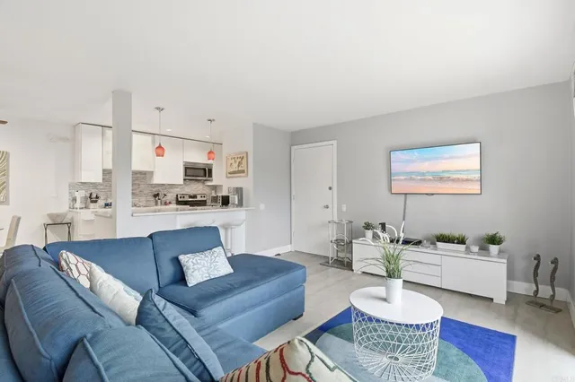a living room with furniture and kitchen view