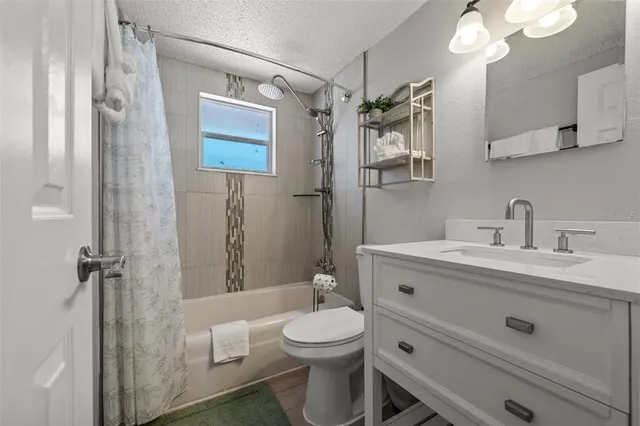 a bathroom with a toilet a sink a mirror a window and vanity