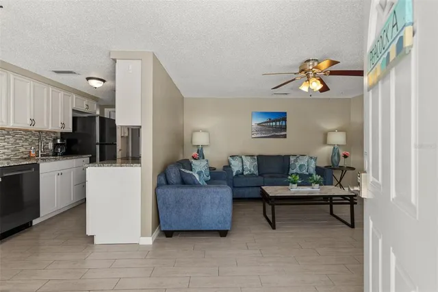 a living room with furniture and a kitchen area