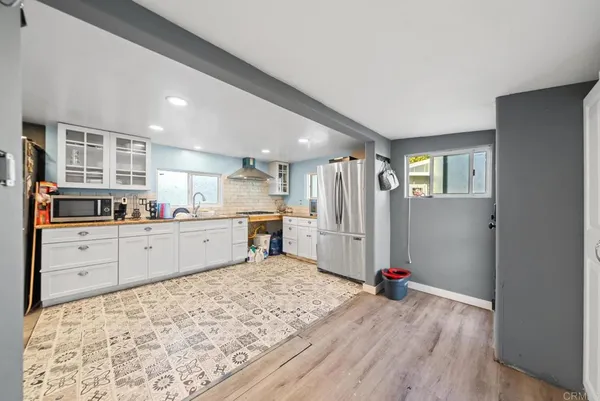 a kitchen with sink refrigerator and cabinets