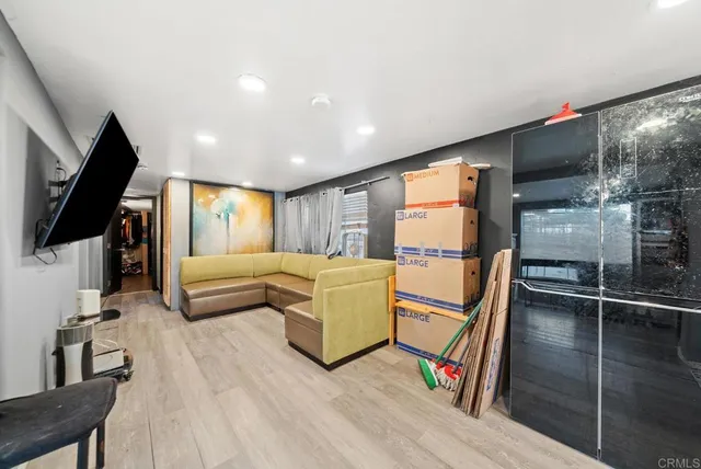 a living room with furniture tv and a flat screen tv