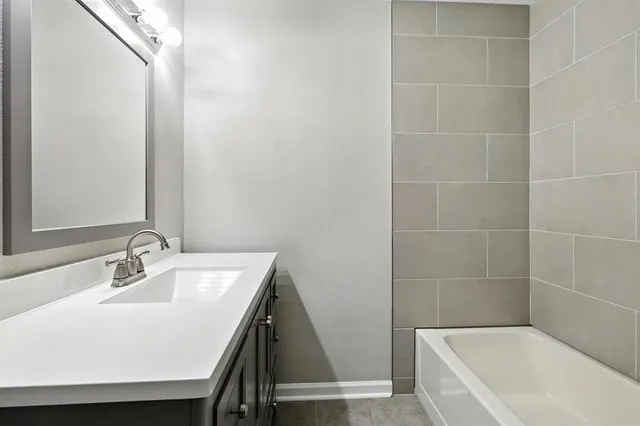 a bathroom with a bathtub a sink and a mirror