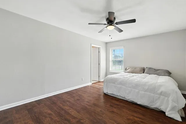 a bedroom with a large bed chandelier and a window