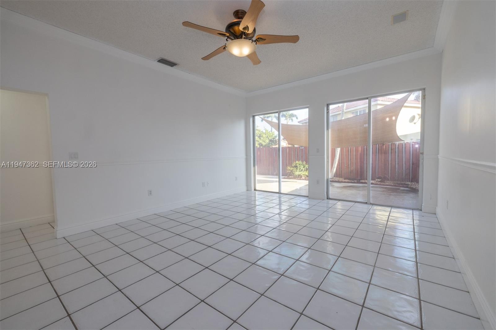 16244 Southwest 81st Street Miami, FL 33193 - Photo 20 of 35 a view of an empty room and window & chandelier fan