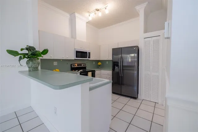 a kitchen with stainless steel appliances a refrigerator sink and microwave