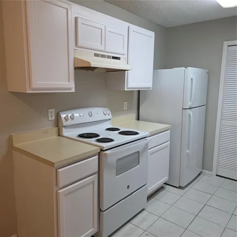 a kitchen with white cabinets and white appliances