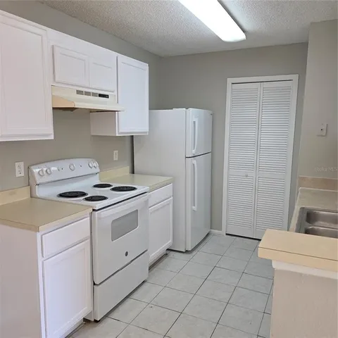 a kitchen with a stove a refrigerator and a sink