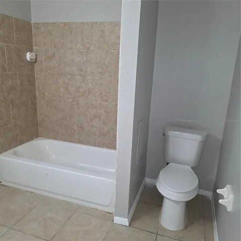 a white toilet sitting next to a bath tub