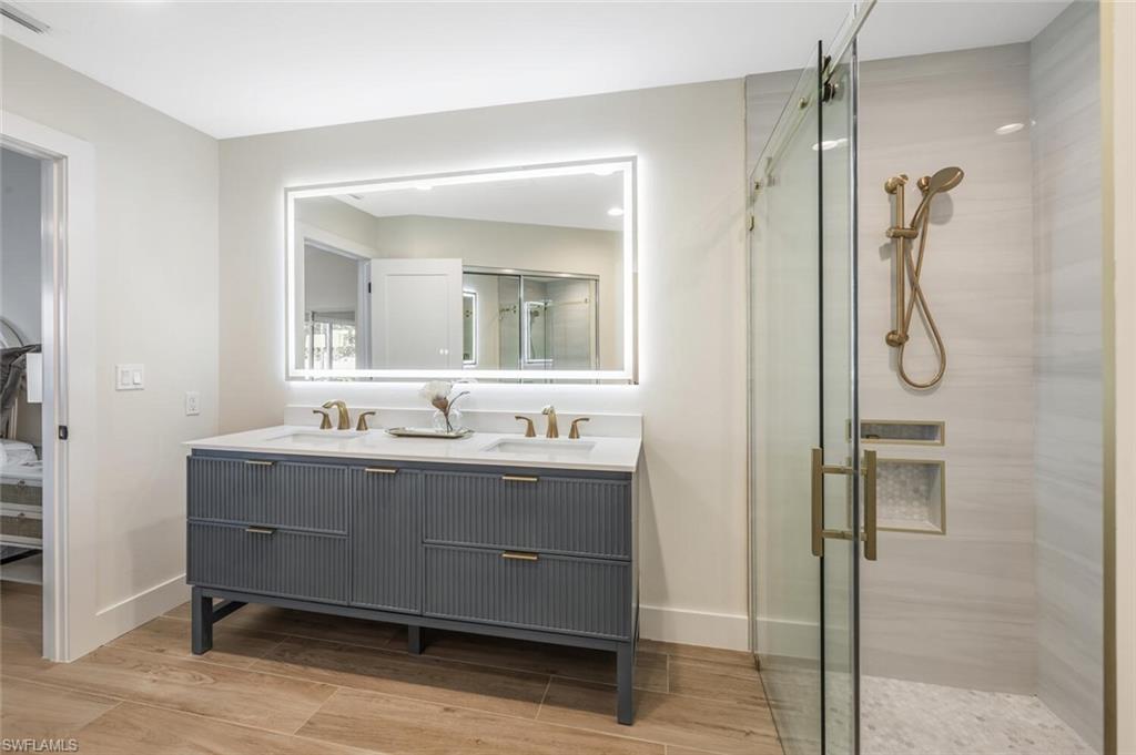 2604 Sailors Way, Unit 120 Naples, FL 34109 - Photo 20 of 27 a bathroom with a granite countertop sink mirror and a shower