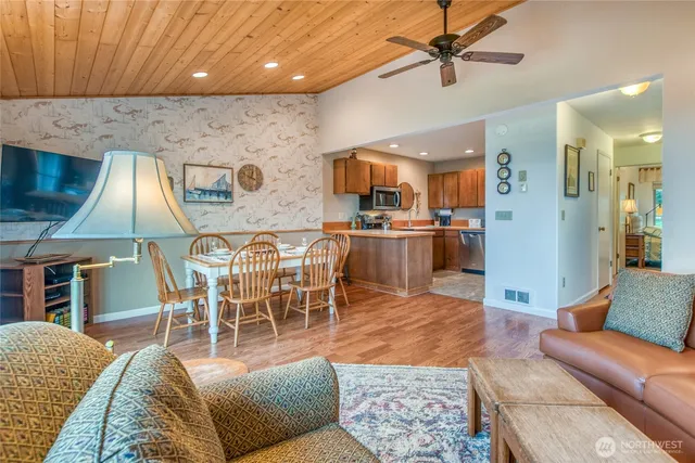 a living room with furniture a flat screen tv and kitchen view