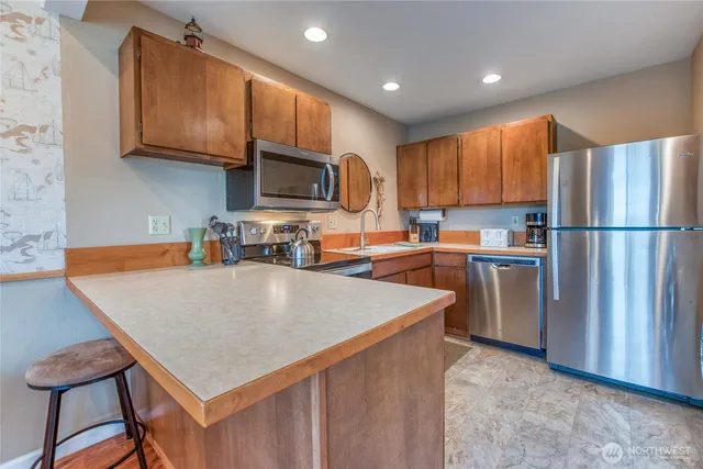 a kitchen with stainless steel appliances granite countertop a refrigerator a stove top oven a sink dishwasher and white cabinets