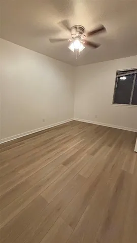 a view of an empty room with a chandelier fan