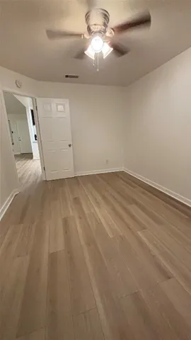 an empty room with a ceiling fan and a window