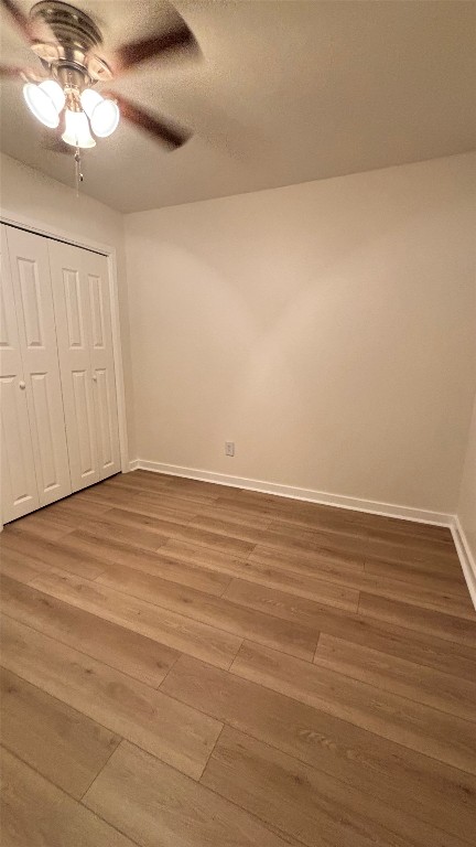 4507 Dorsett Oaks Circle, Unit A Austin, TX 78727 - Photo 15 of 26 Bedroom featuring light wood-style flooring, ceiling fan, a closet, and a textured ceiling