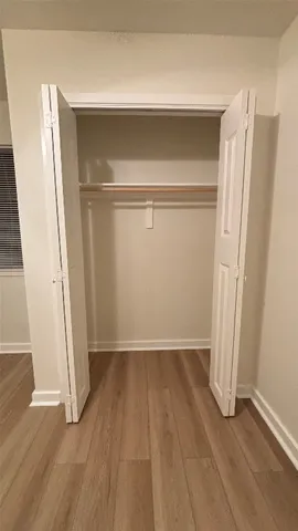 an empty room with wooden floor and a window