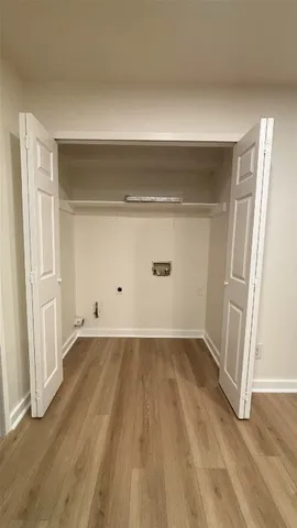 a view of an empty room with wooden floor and closet